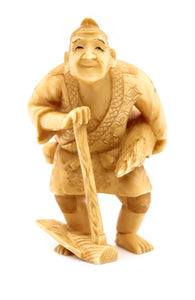 JAPAN 1910 MEIJI PERIOD CARVED SCULPTURE FIGURINE OF A STANDING FARMER WITH TOOLS