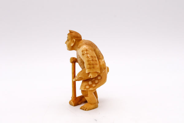 JAPAN 1910 MEIJI PERIOD CARVED SCULPTURE FIGURINE OF A STANDING FARMER WITH TOOLS