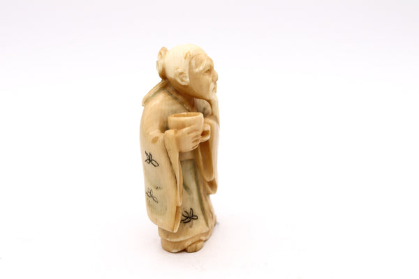 JAPAN 1900'S MEIJI PERIOD CARVED NETSUKE OF A STANDING OLD MAN WITH VESSEL